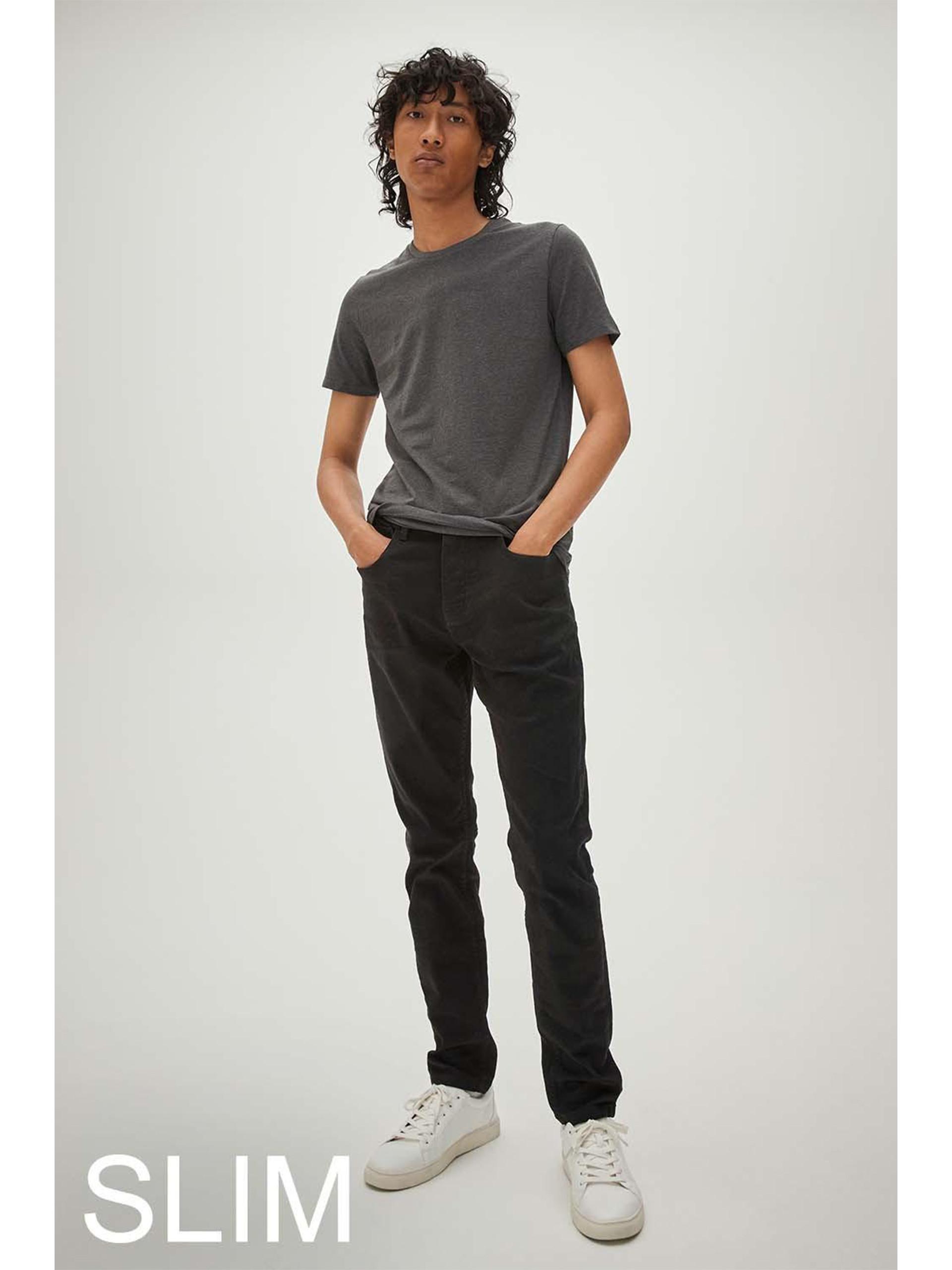 Model wears black slim denim jeans