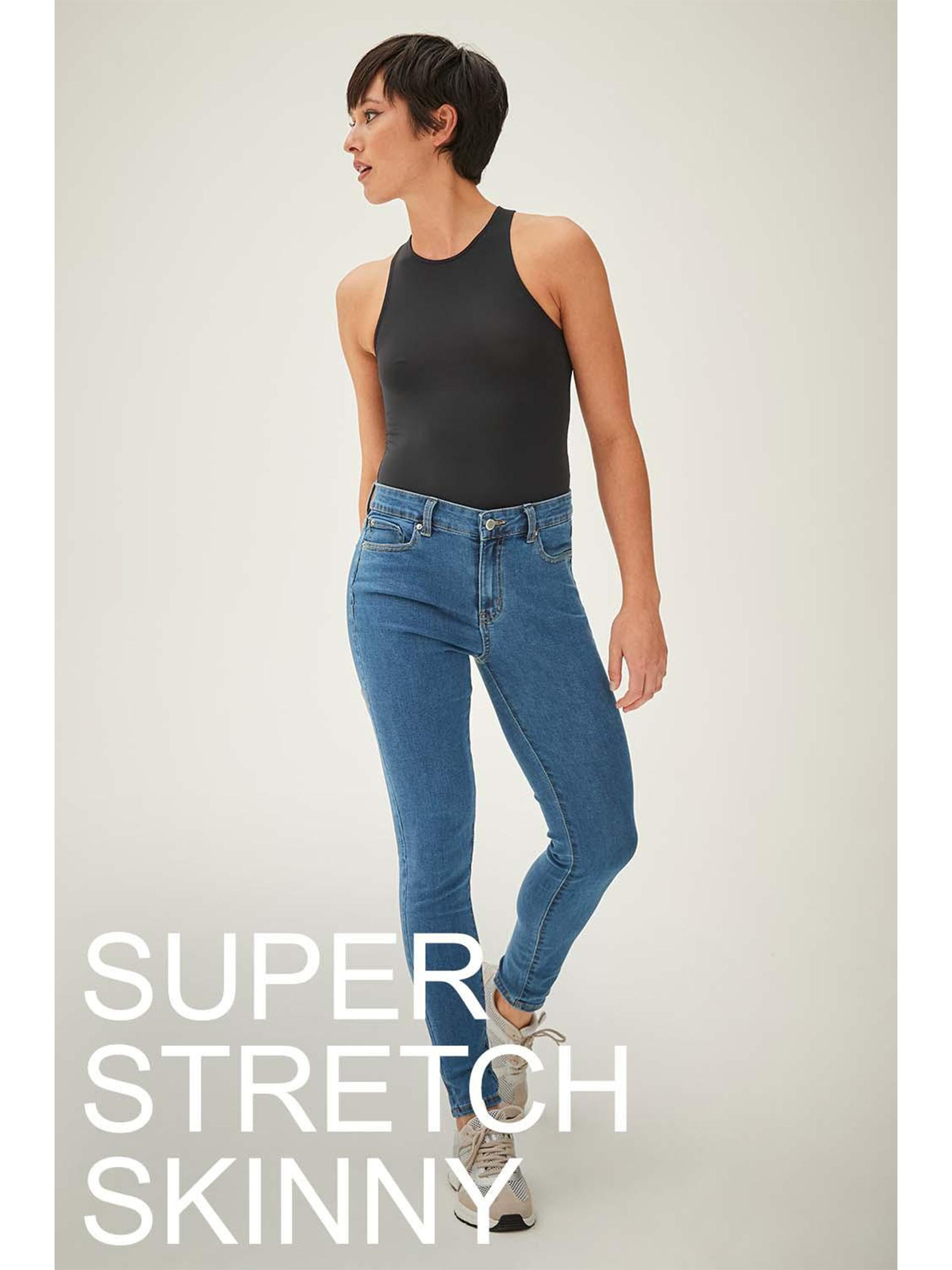 Model wears blue super stretch skinny jeans