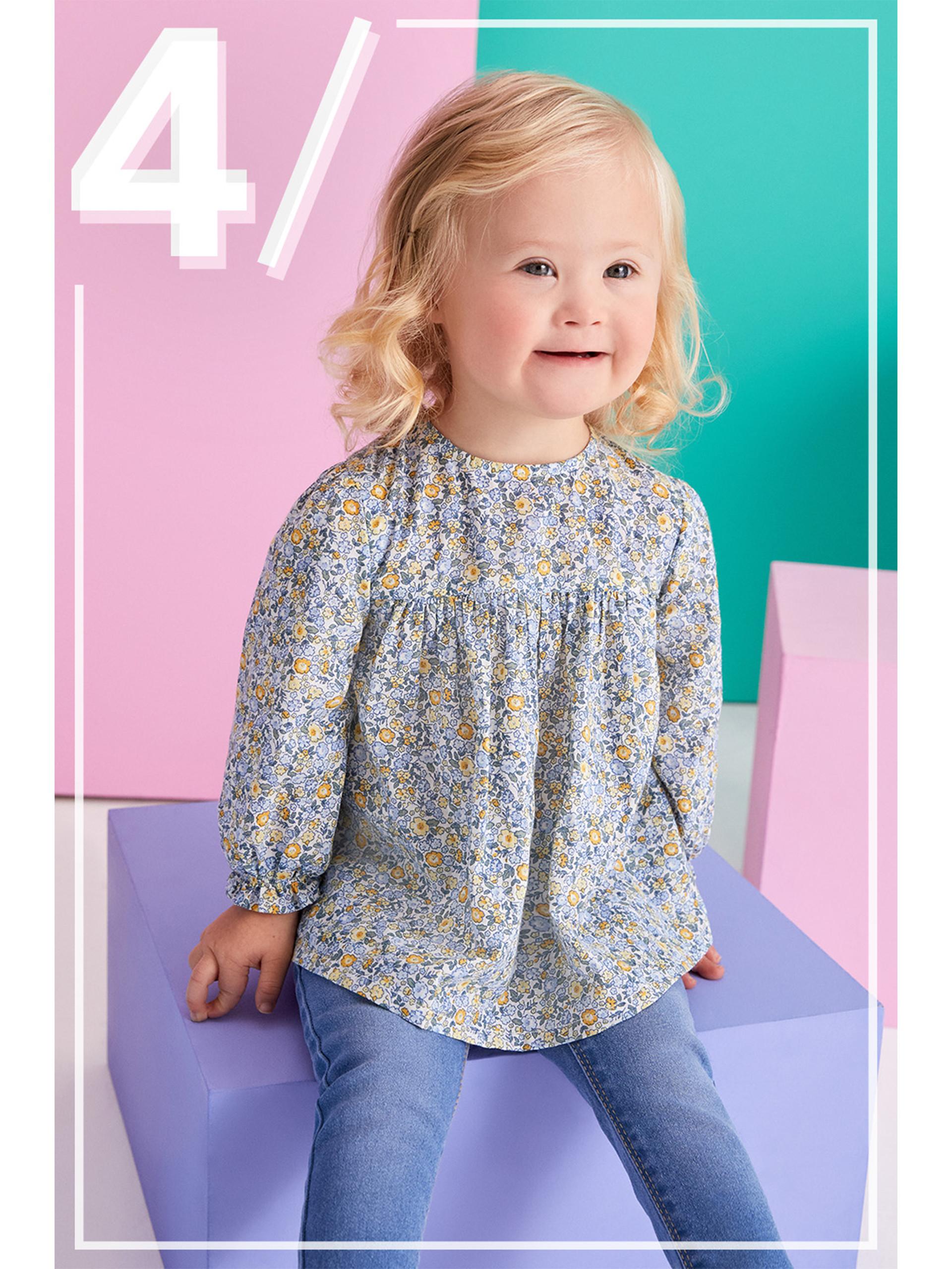 Modelo infantil con vaqueros y blusa floral