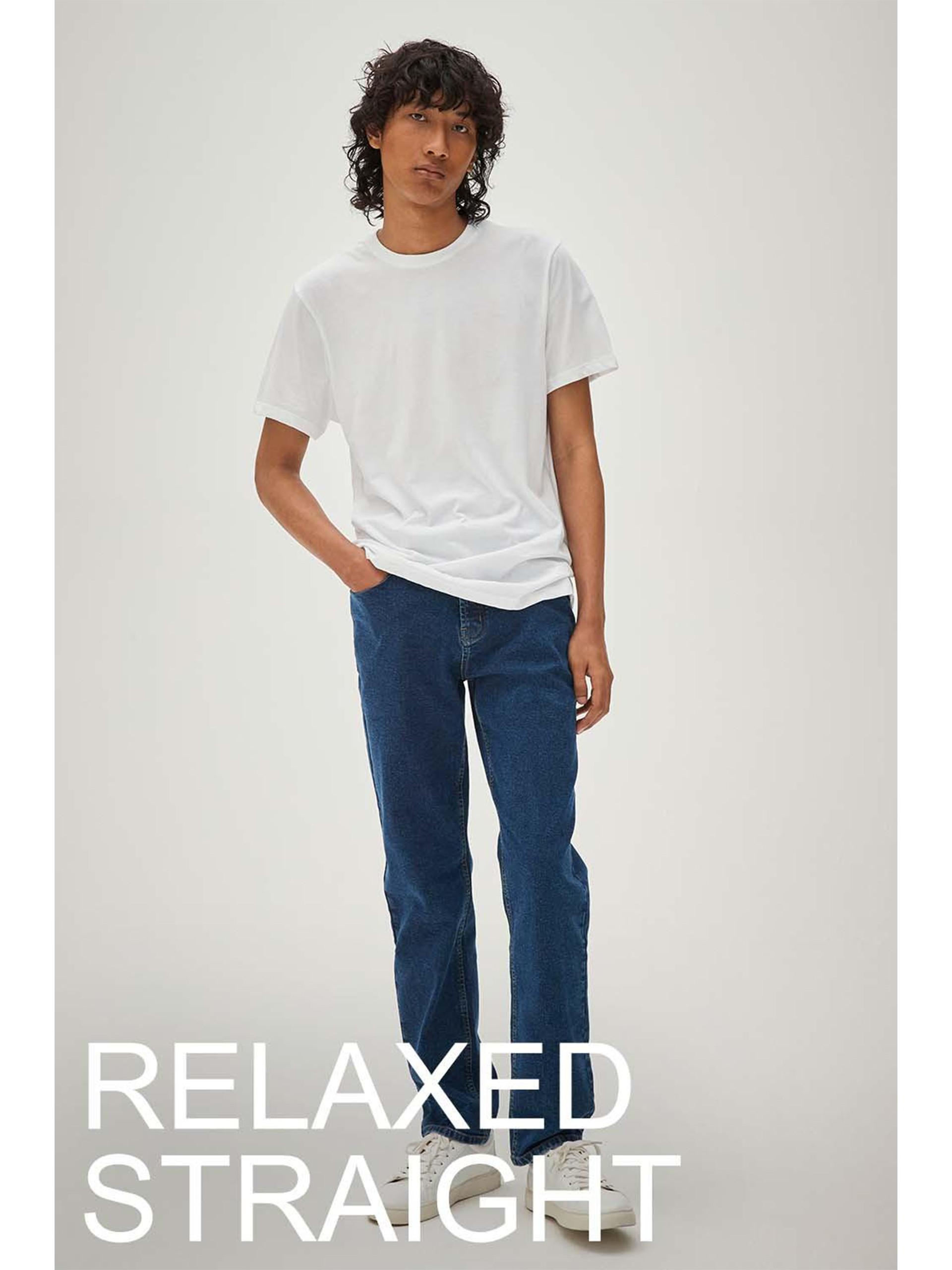 Model wears blue relaxed fit jeans