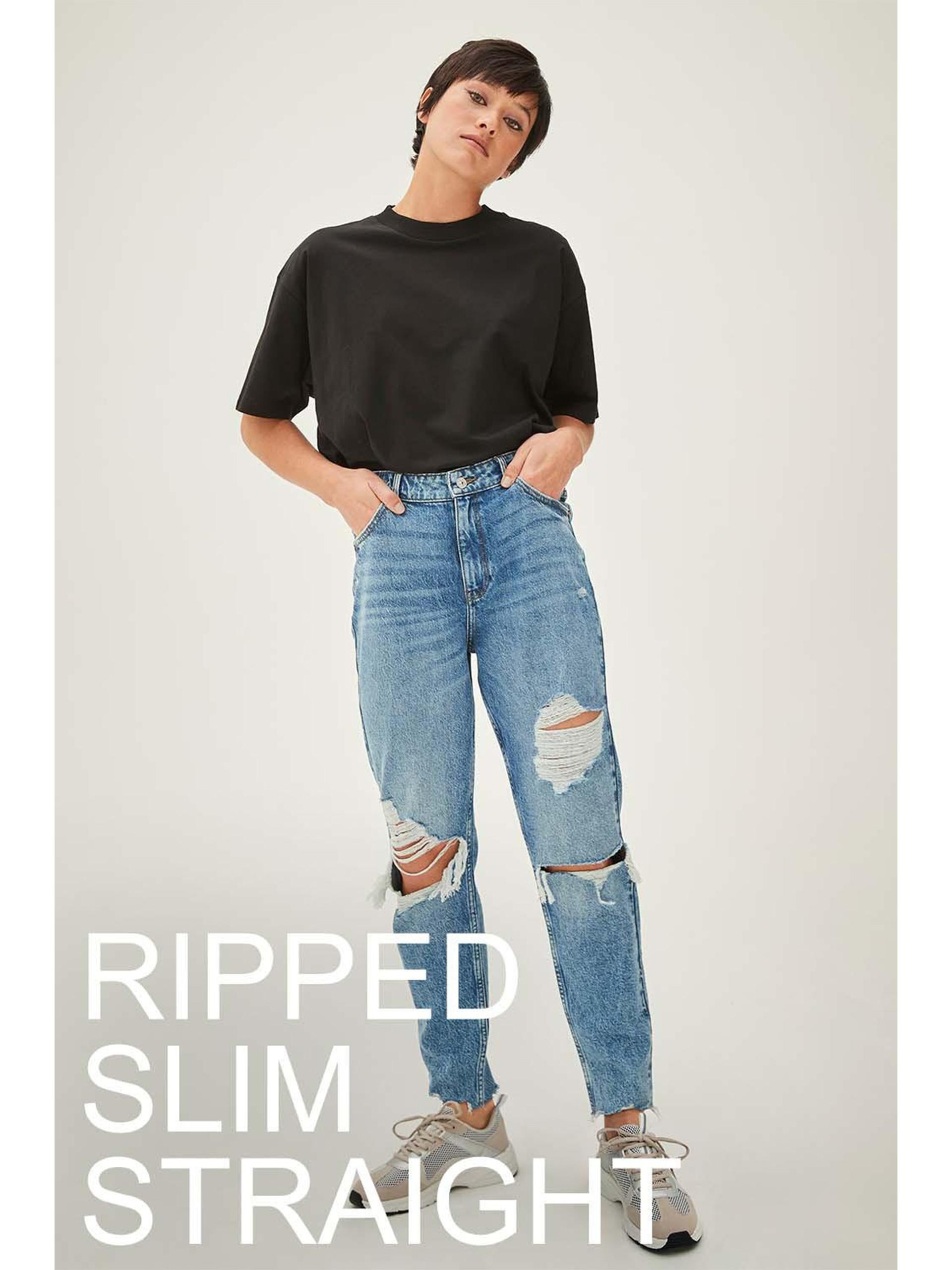 Model wears straight leg ripped jeans