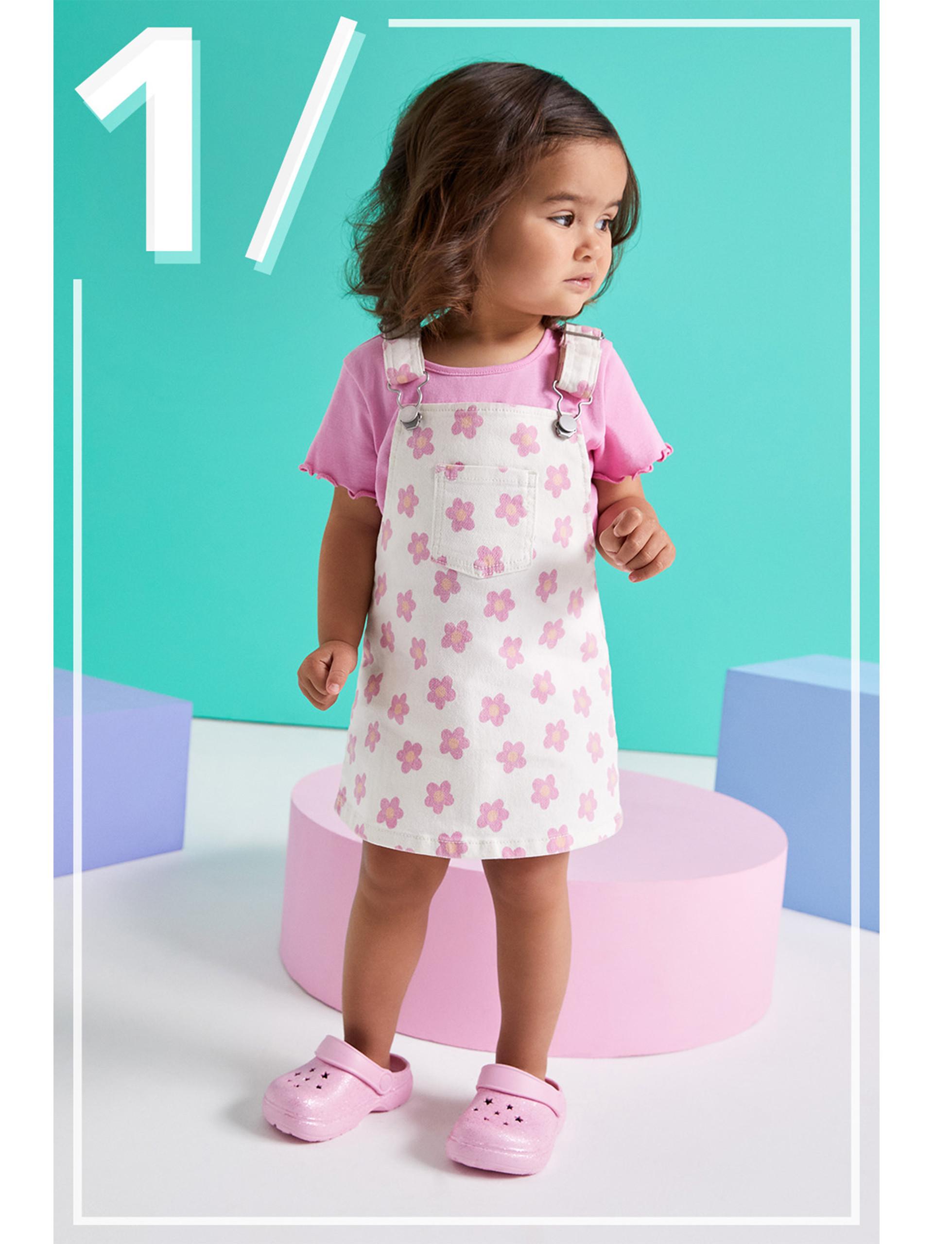 Modelo infantil con camiseta rosa y pichi de flores