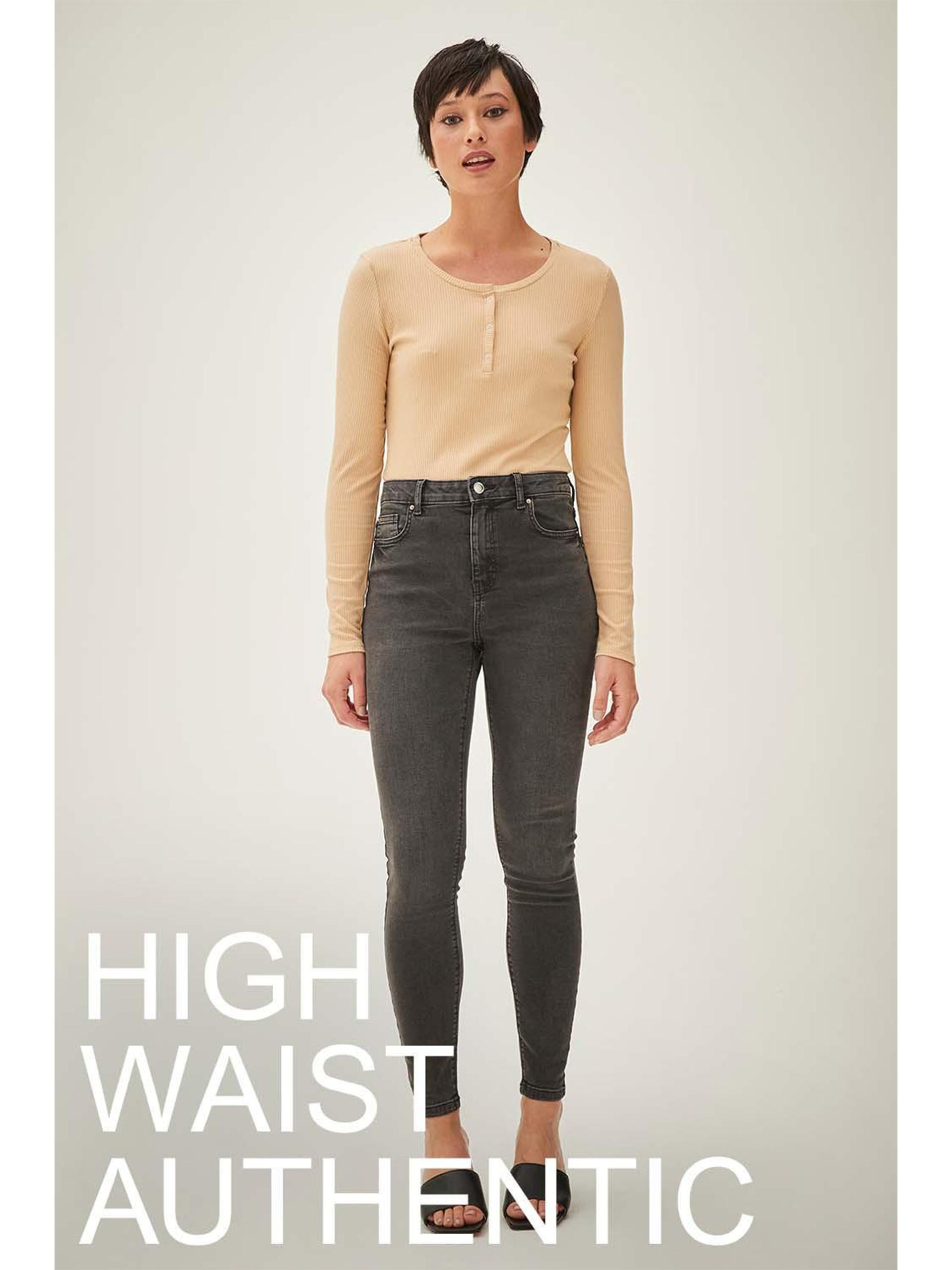 Model wears high waisted grey skinny jeans