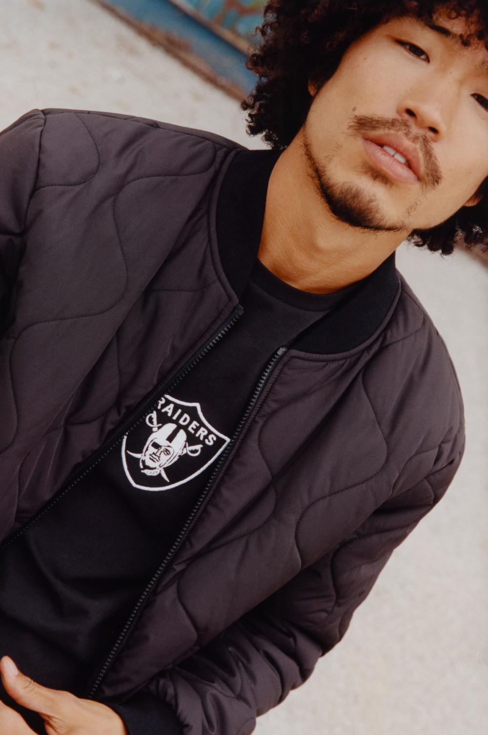 Model trägt einen schwarzen NFL Pullover mit Rundhalsausschnitt