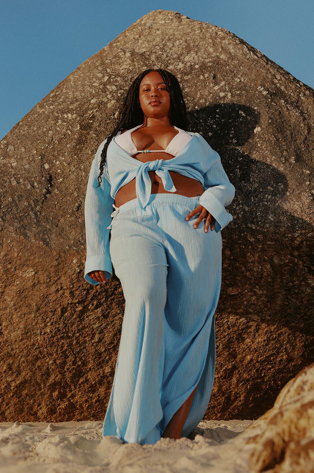 Model in blauwe matchende set over witte bikini met kralen