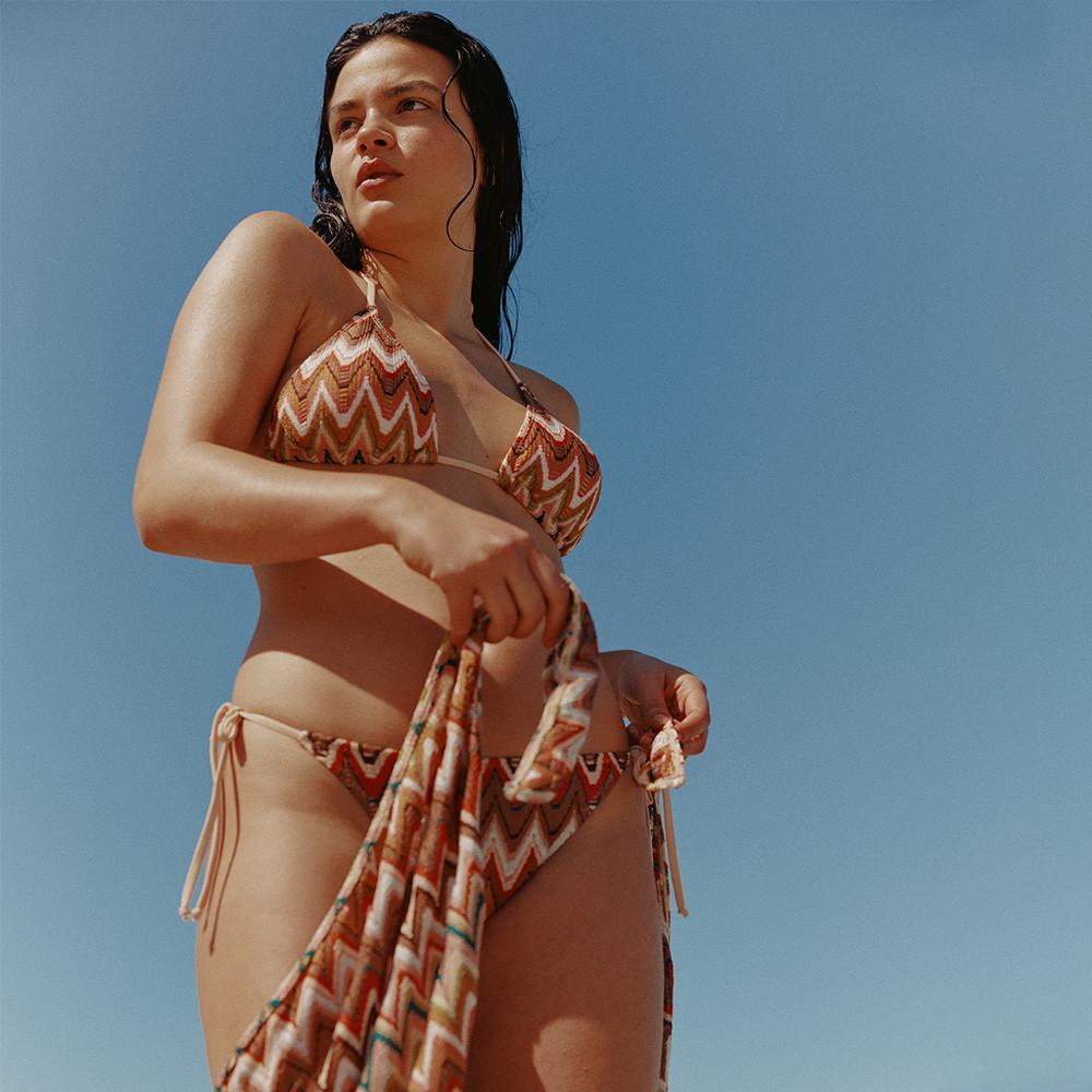 Model in orange and white print bikini