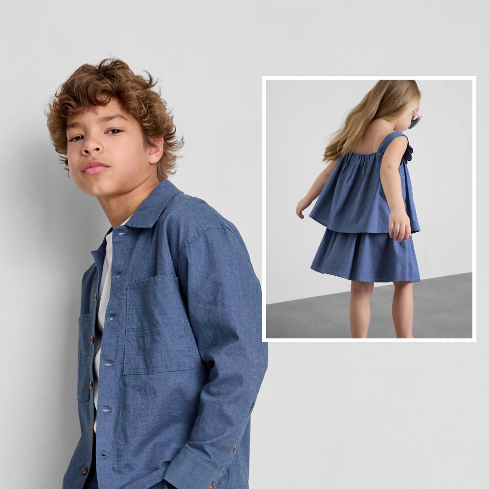 Boy wearing blue denim jacket and girl in blue tiered dress, both in matching chambray fabric.
