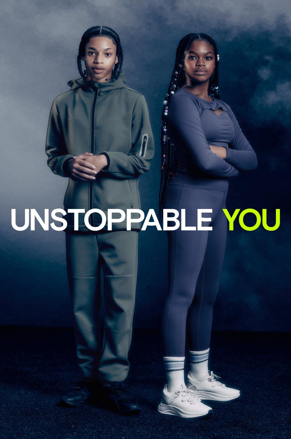 Child wearing khaki tracksuit with black trainers and second child wearing matching navy long sleeve gym top and leggings with white trainers