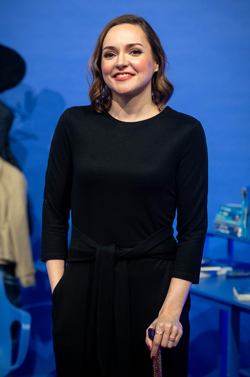 Fashion designer Victoria Jenkins wearing a long sleeve black dress and holding a walking cane.