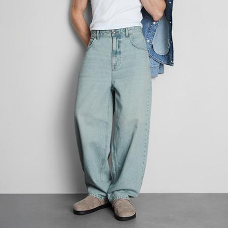 Light blue baggy wide-leg jeans paired with white top, denim jacket and beige shoes.