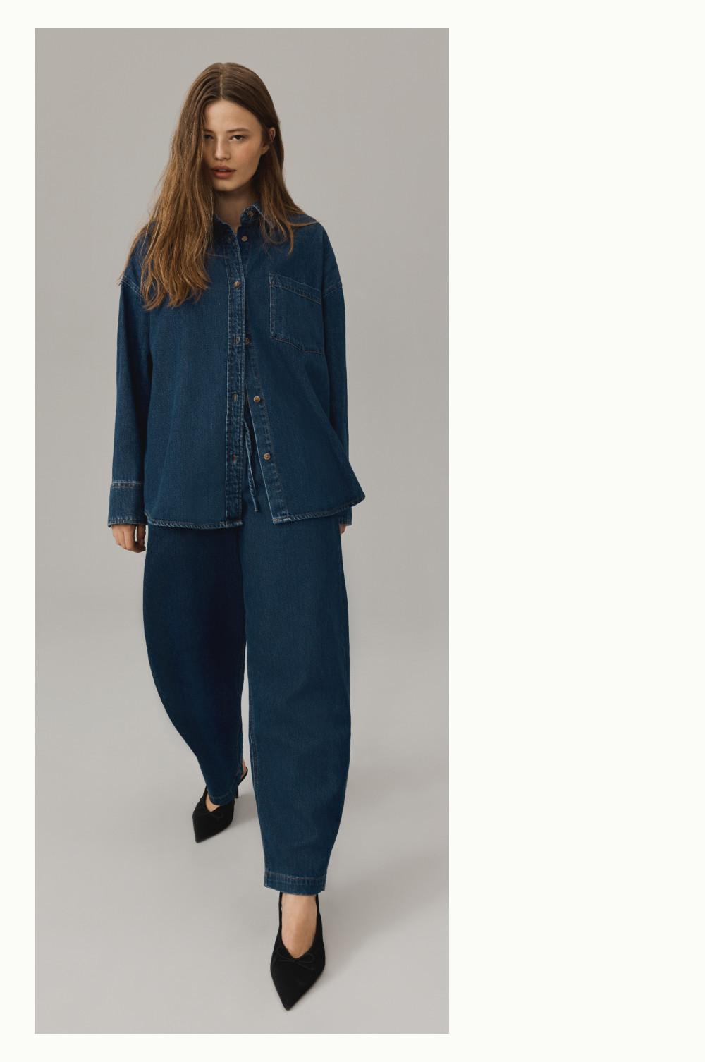 Oversized denim outfit featuring button-up shirt and wide-leg trousers paired with black pointed shoes.