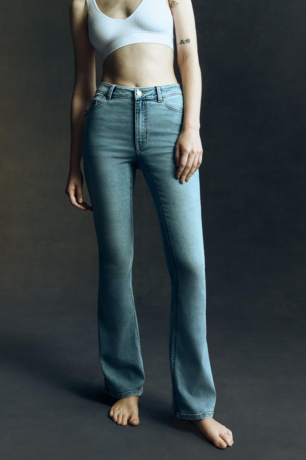 Model trägt Bootcut-Jeans aus hellblauem Denim