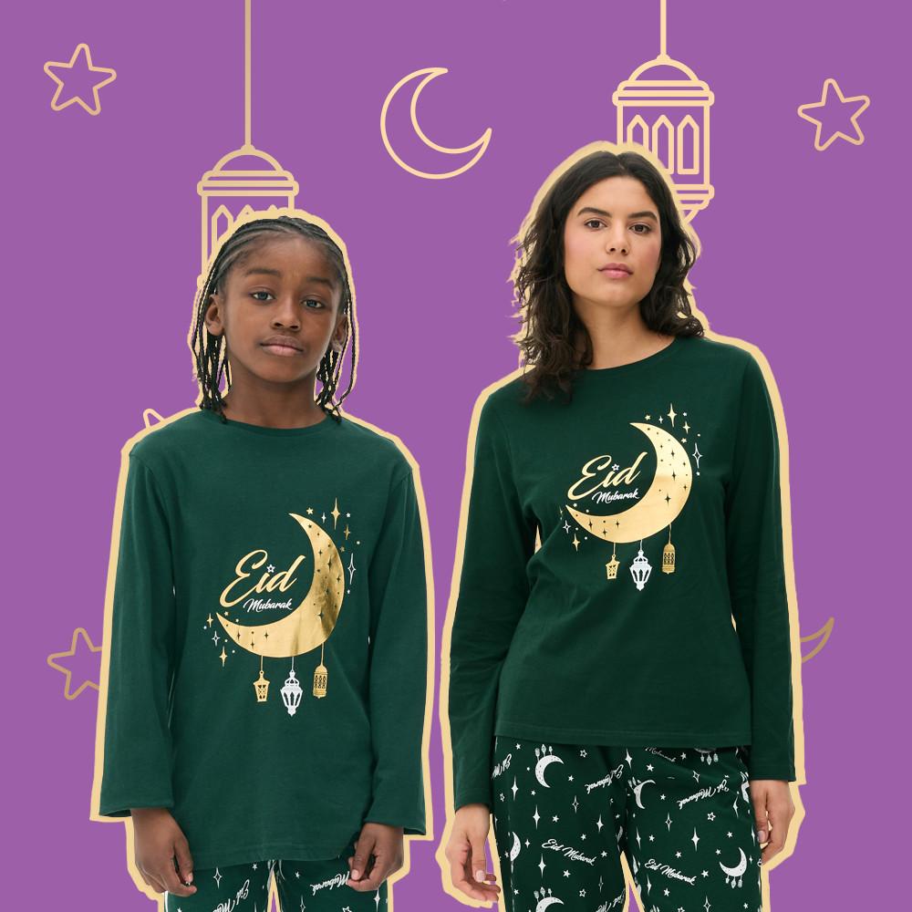 Model and kid wearing green long-sleeved top with gold-toned Eid Mubarak crescent moon and lantern design paired with star print bottoms.