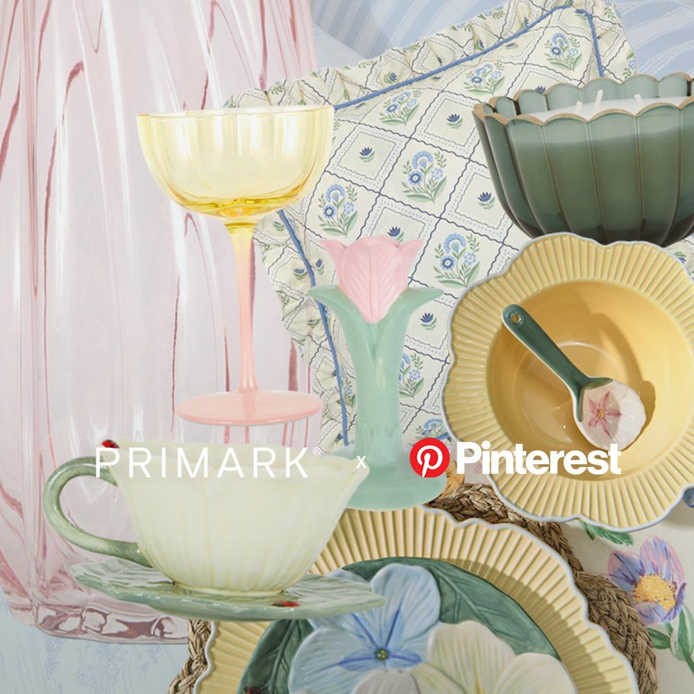 Pastel-coloured homeware collage with floral plates, yellow wine glass, and mint green vase with pink tulip against floral fabric.