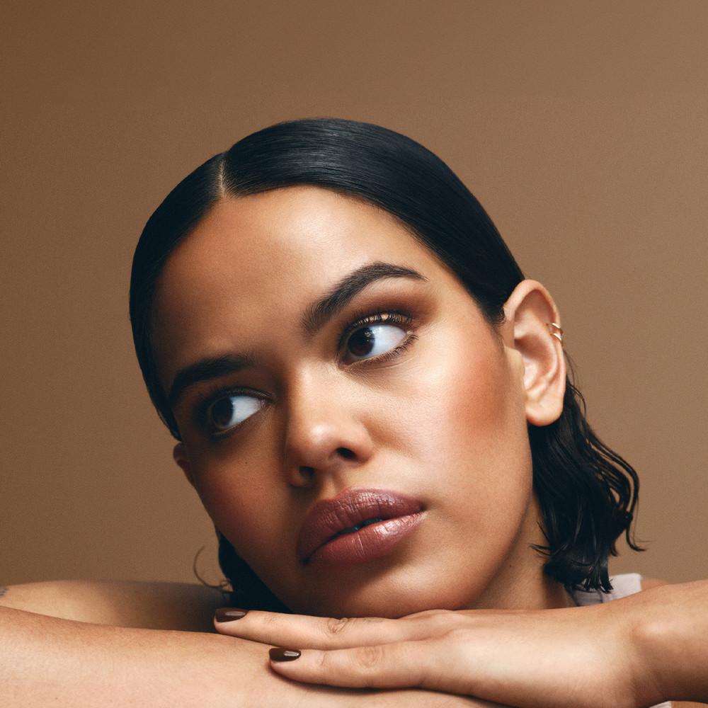 Model wearing gold tone, bronzed make up