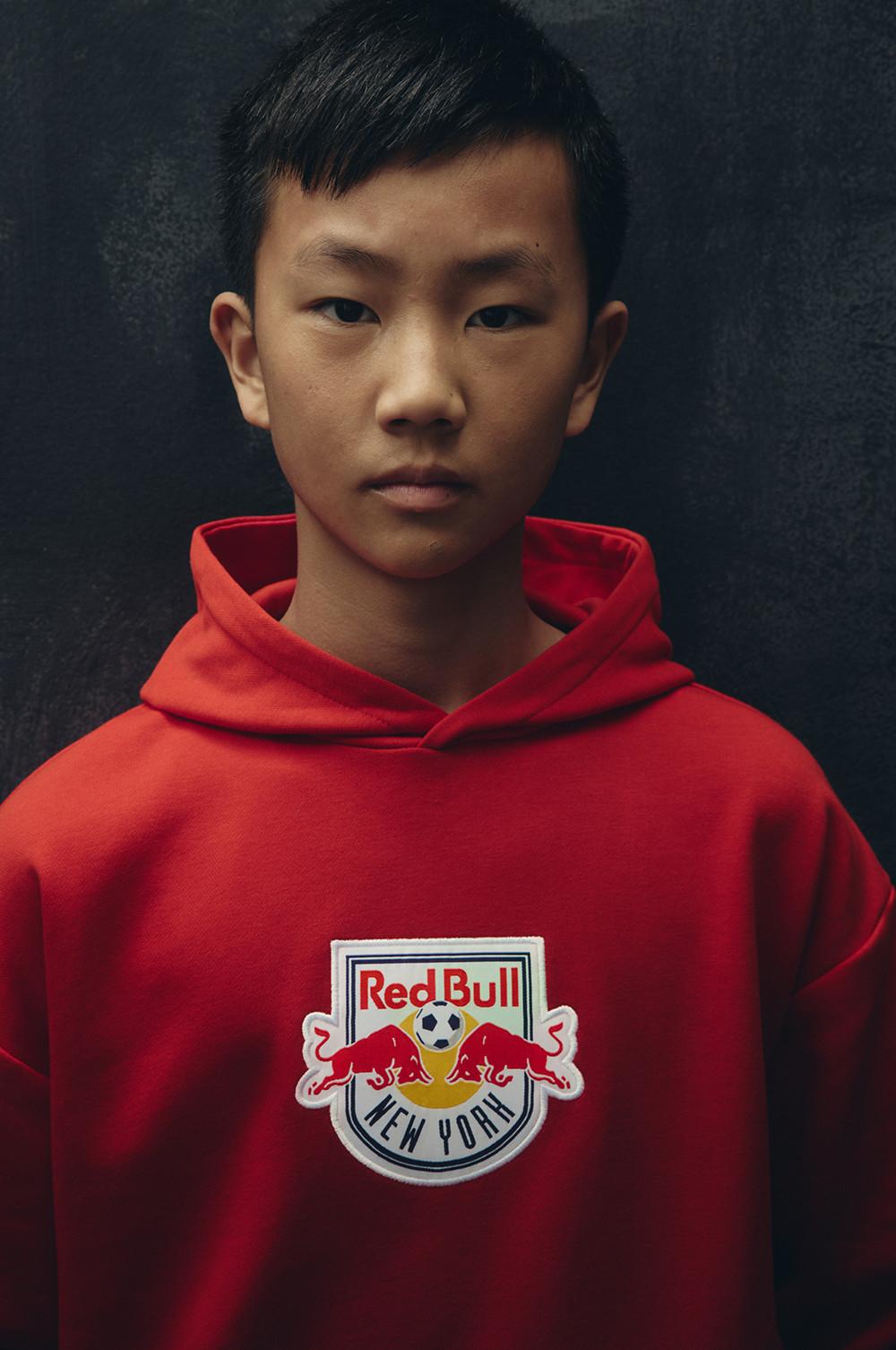 Rotes Kapuzensweatshirt mit dem Logo des Fußballclubs Red Bull New York auf der Brust.