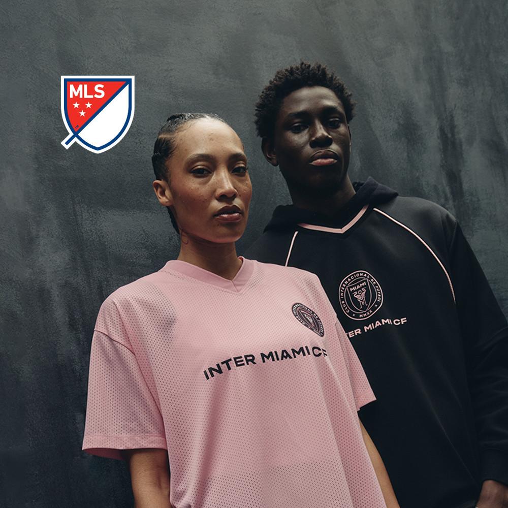 Zwei Models mit Fußballtrikots von Inter Miami CF in Pink und Schwarz und einem darüber abgebildeten MLS-Logo.