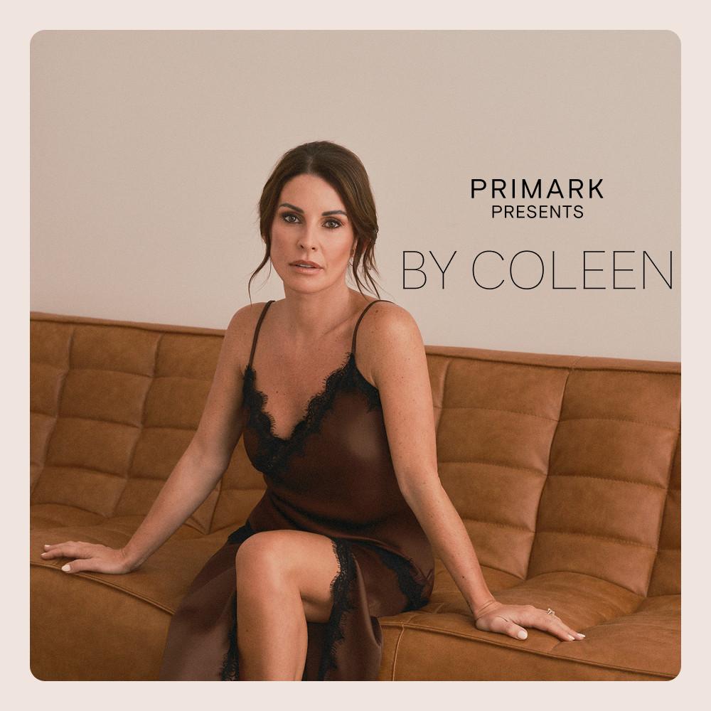 Woman sitting on a tan sofa wearing a black lace-trimmed slip dress from Primark Presents By Coleen collection.