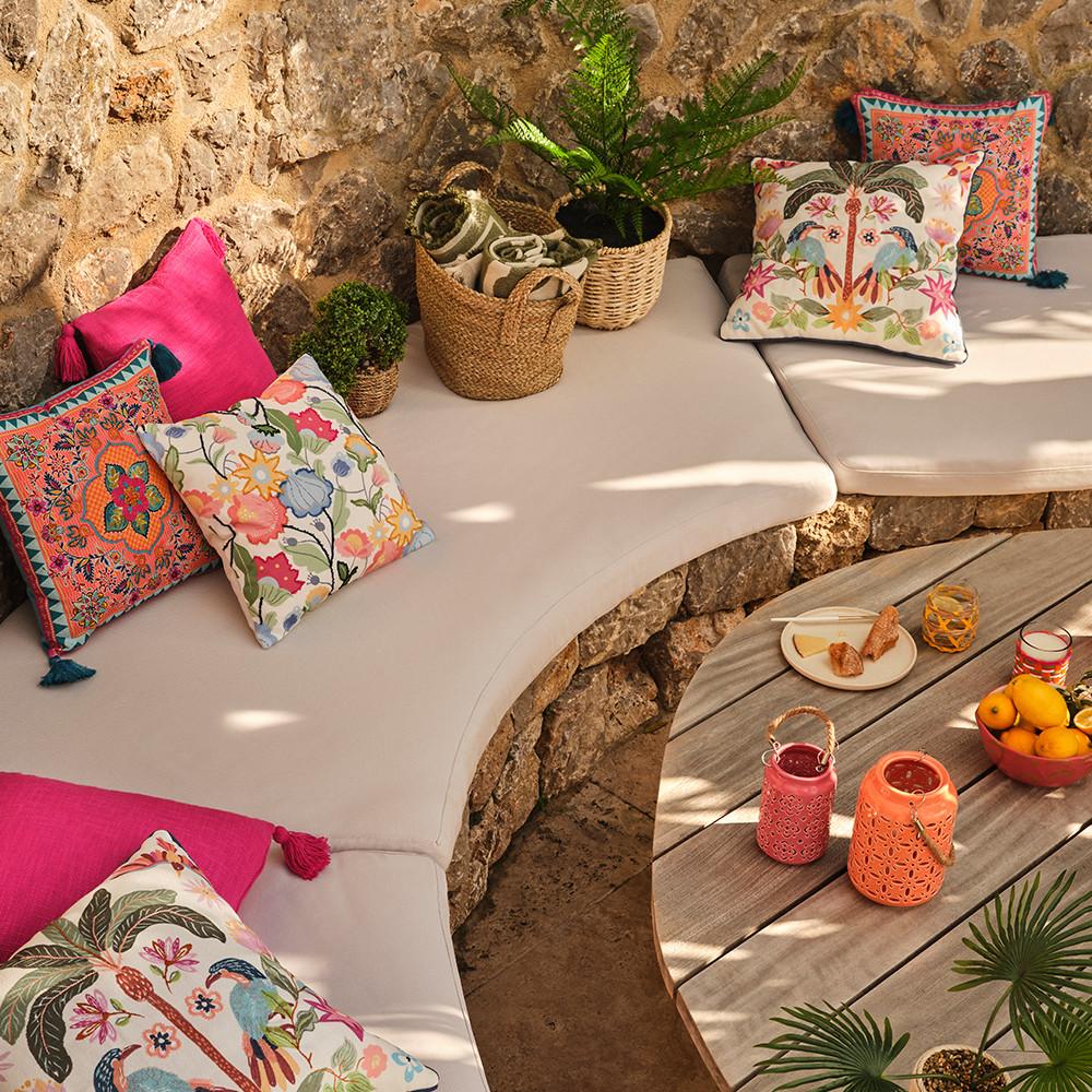 Imagem de cenário exterior com almofadas decorativas e plantas