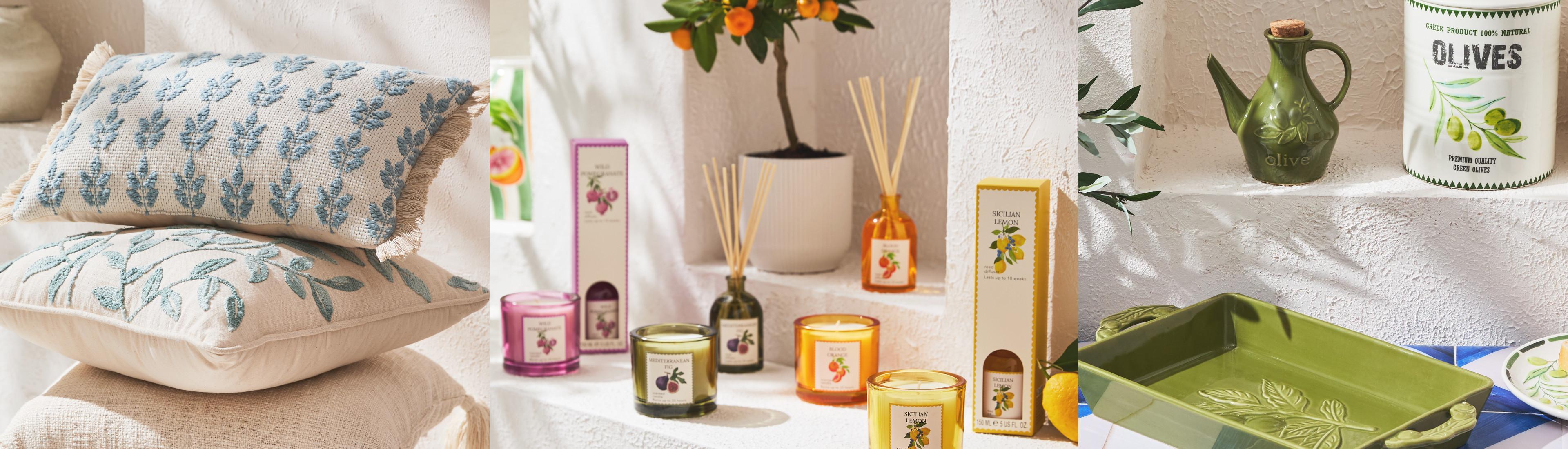 Collection d’articles de décoration inspirés de la méditerranée comprenant des bougies parfumées, des diffuseurs à bâtonnets, des coussins et des plateaux.