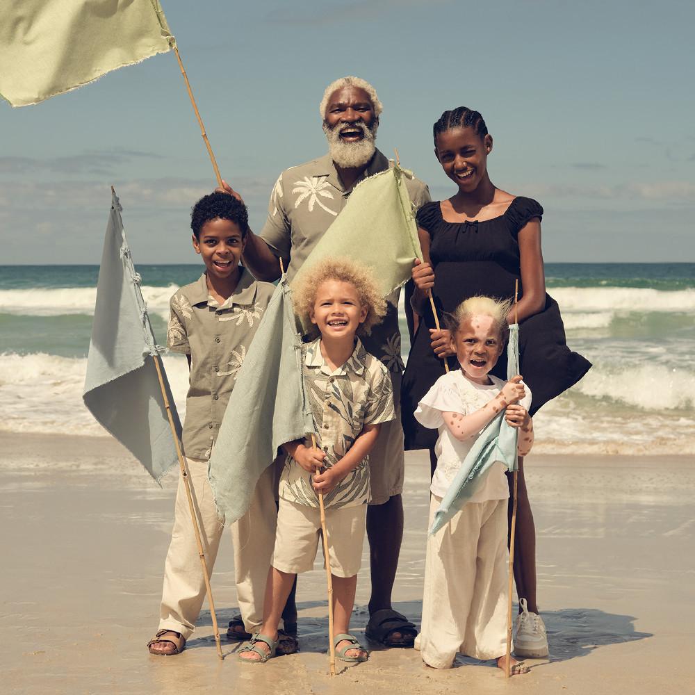 Famiglia che indossa completi estivi in spiaggia