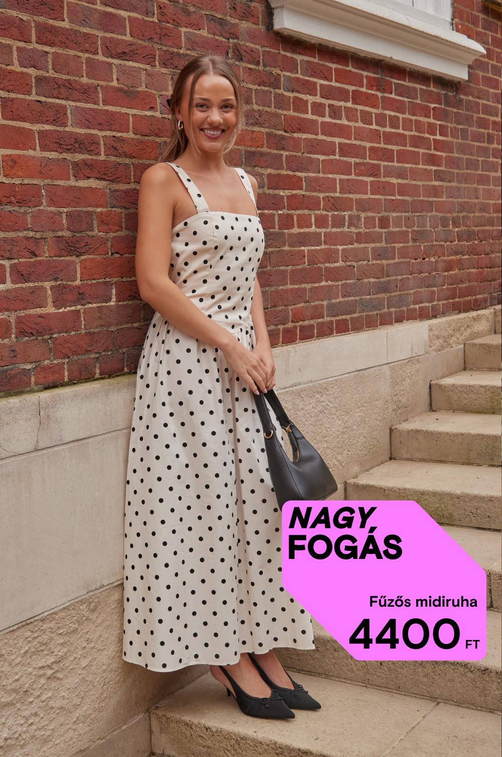 A modell egy kőlépcsőn áll bézs pöttyös maxiruhában, fekete kiegészítőkkel.