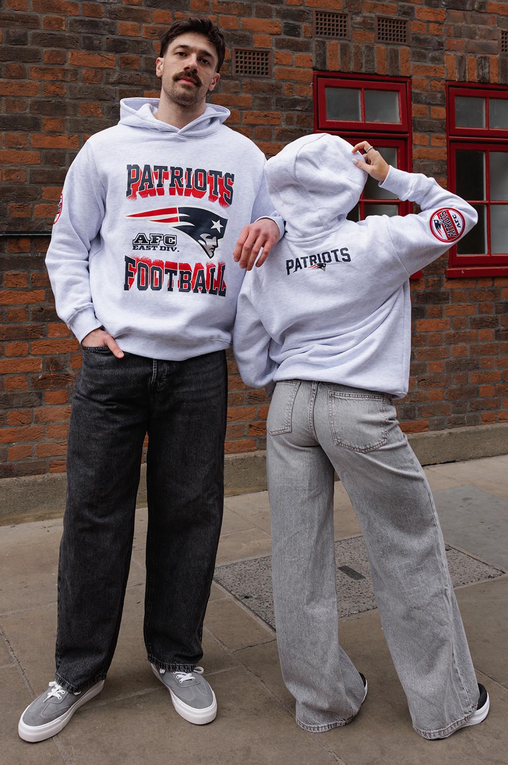 Two people wearing grey Patriots hoodies, one facing forward, the other with back turned.