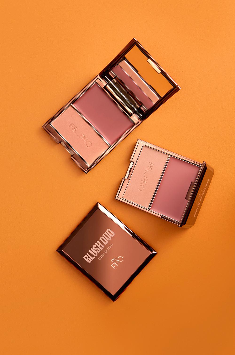 Due ciprie PS... Pro compatte su sfondo arancione, con palette bicolore in tonalità rosa e confezione in oro rosato.