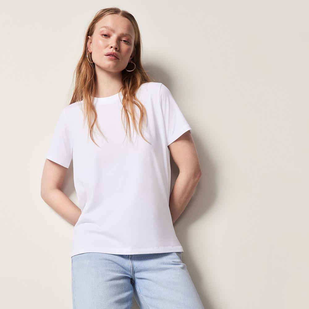 Frau in weißem T-Shirt und blauer Jeans