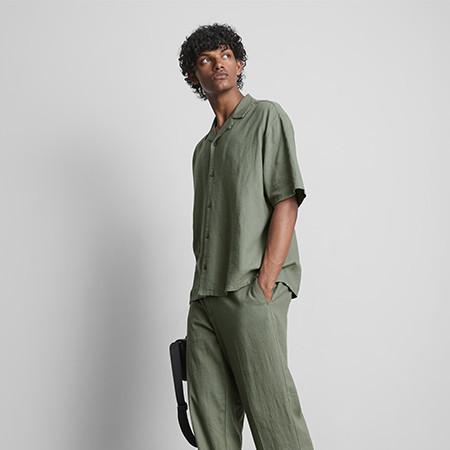 Green corduroy jacket with button fastening worn over white t-shirt, paired with matching trousers.