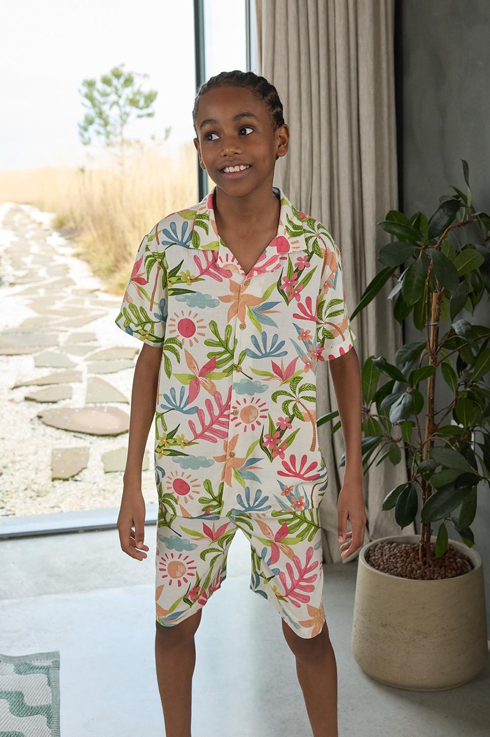 Enfant portant un ensemble coordonné avec short et chemise à imprimé fleuri