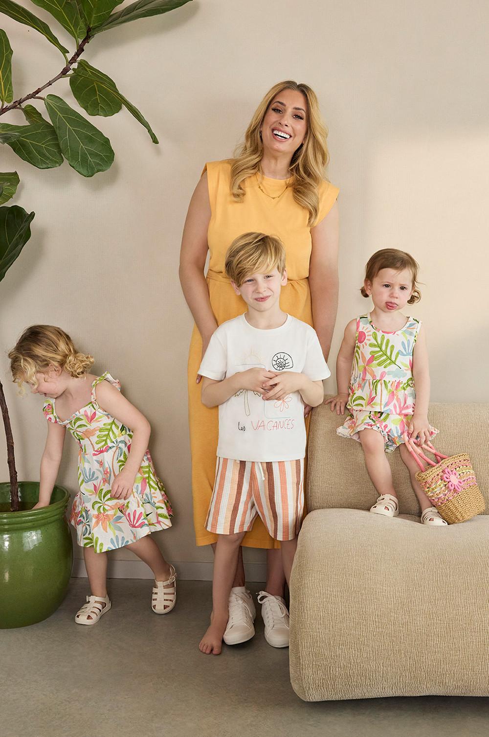 Stacey Solomon con un vestido amarillo y sus hijos con un conjunto a juego, un vestido y pantalones cortos, todos ellos estampados.