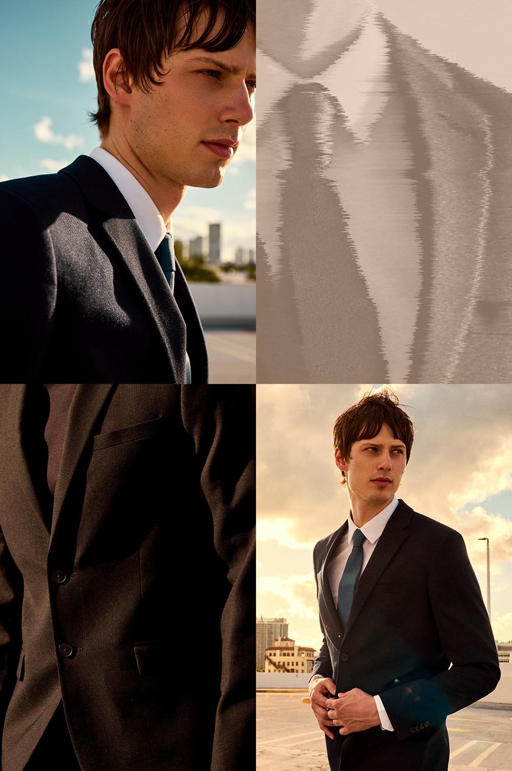 Modelo con traje de vestir gris oscuro, camisa blanca y corbata en un entorno urbano.
