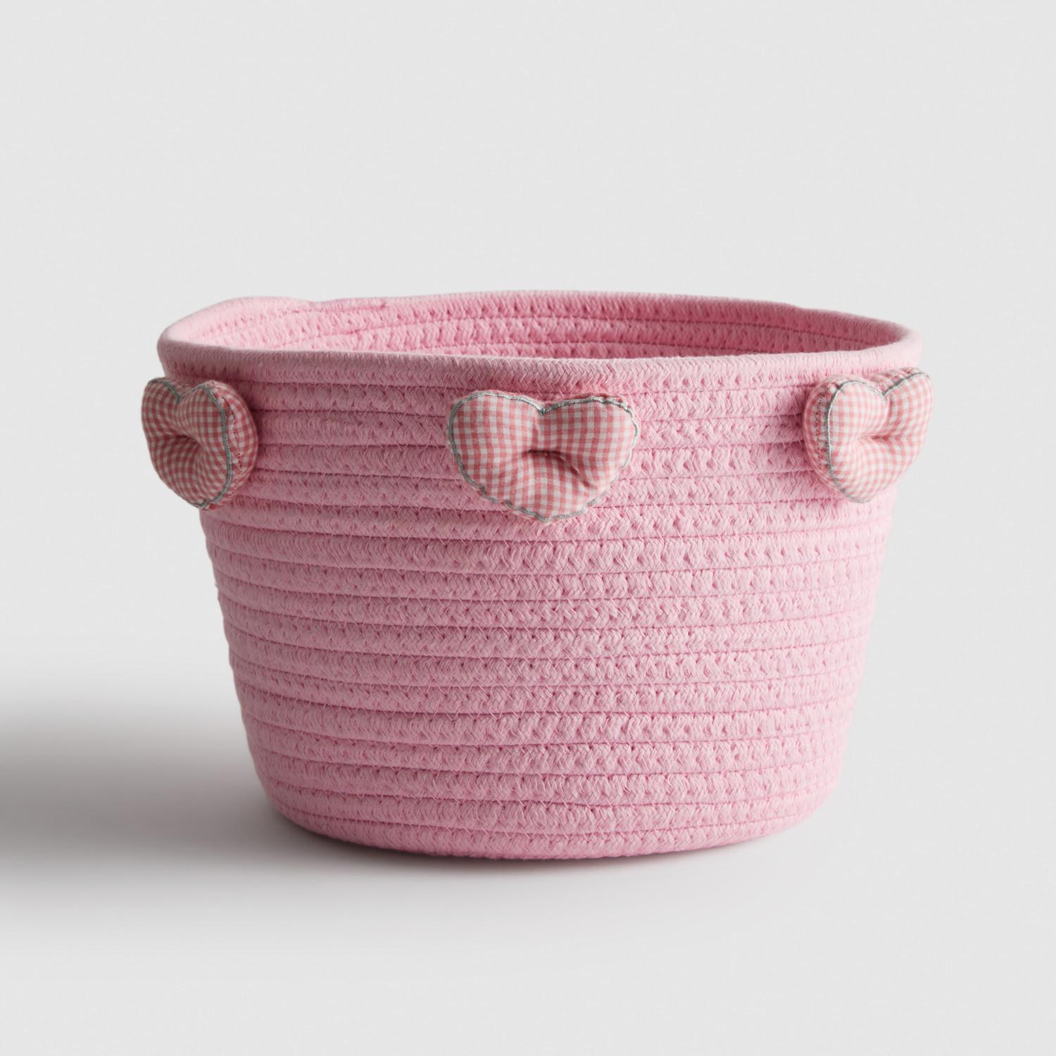 Pink woven storage basket with gingham heart-shaped handles.
