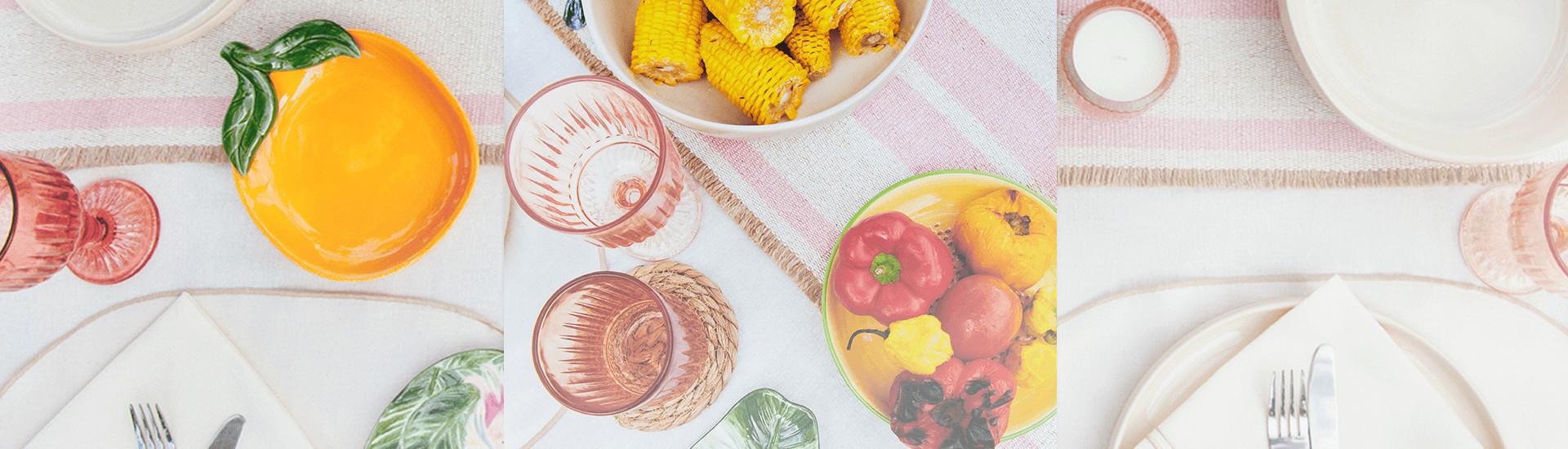 Table set with summery tableware including woven floral mats and fruit shaped dish plates.