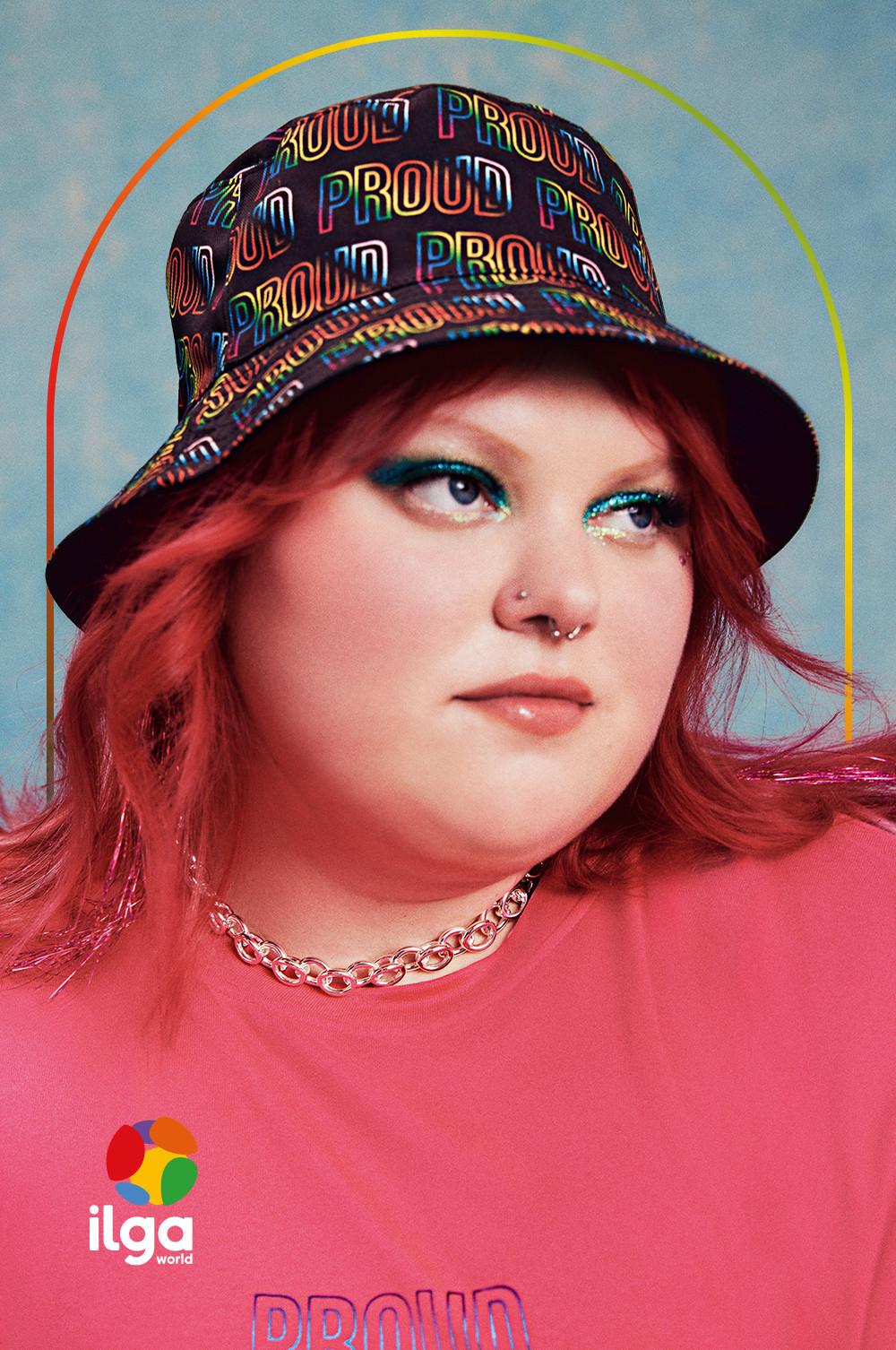 Modella che indossa ombretto glitterato, T-shirt del Pride e cappello alla pescatora