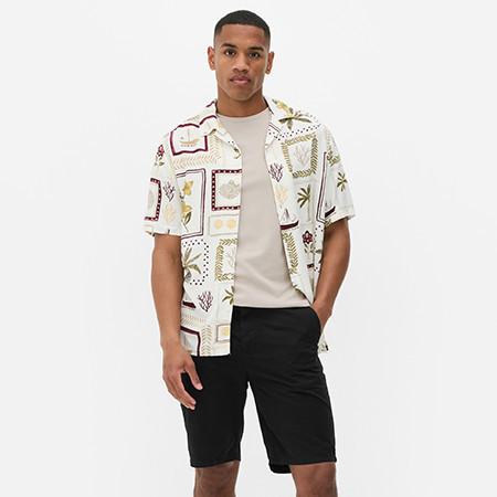 Model wearing floral print shirt and black shorts