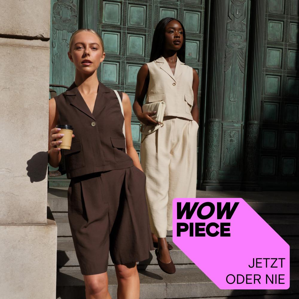 Zwei Models, die ärmellose, taillierte Kombiteile in Braun und Creme tragen, stehen draußen und halten Kaffeetassen in der Hand