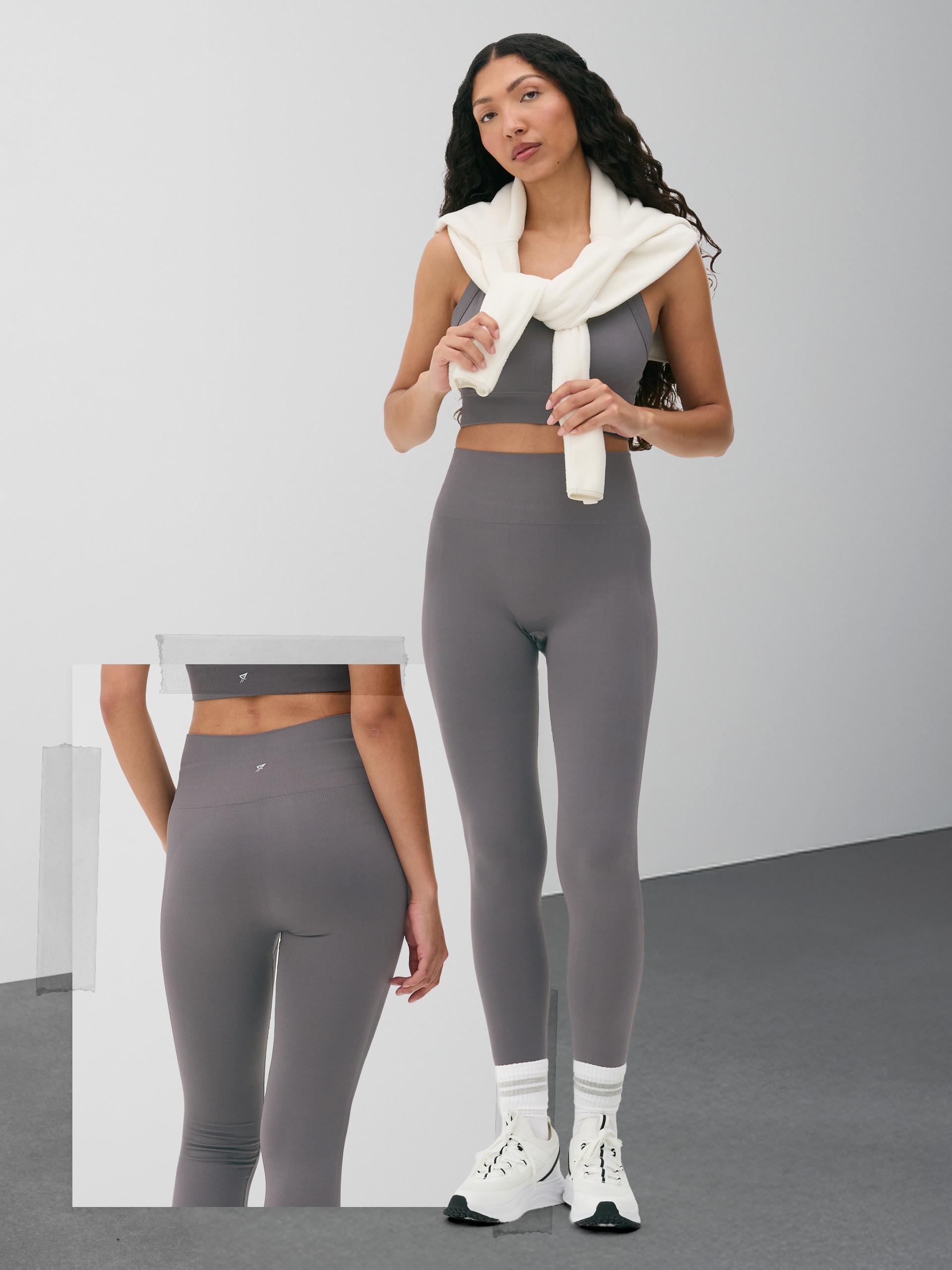 Person wearing grey activewear set with crop top and leggings, white scarf, and white trainers.