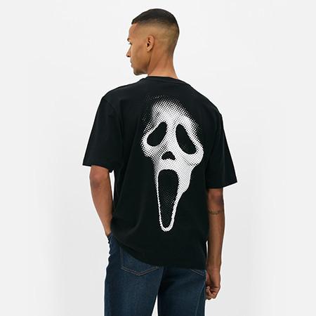 Person wearing black t-shirt with Ghostface mask graphic on the back, viewed from behind.