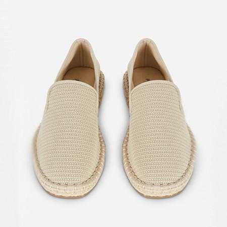 Beige textured slip-on espadrilles with woven uppers and traditional rope trim soles.