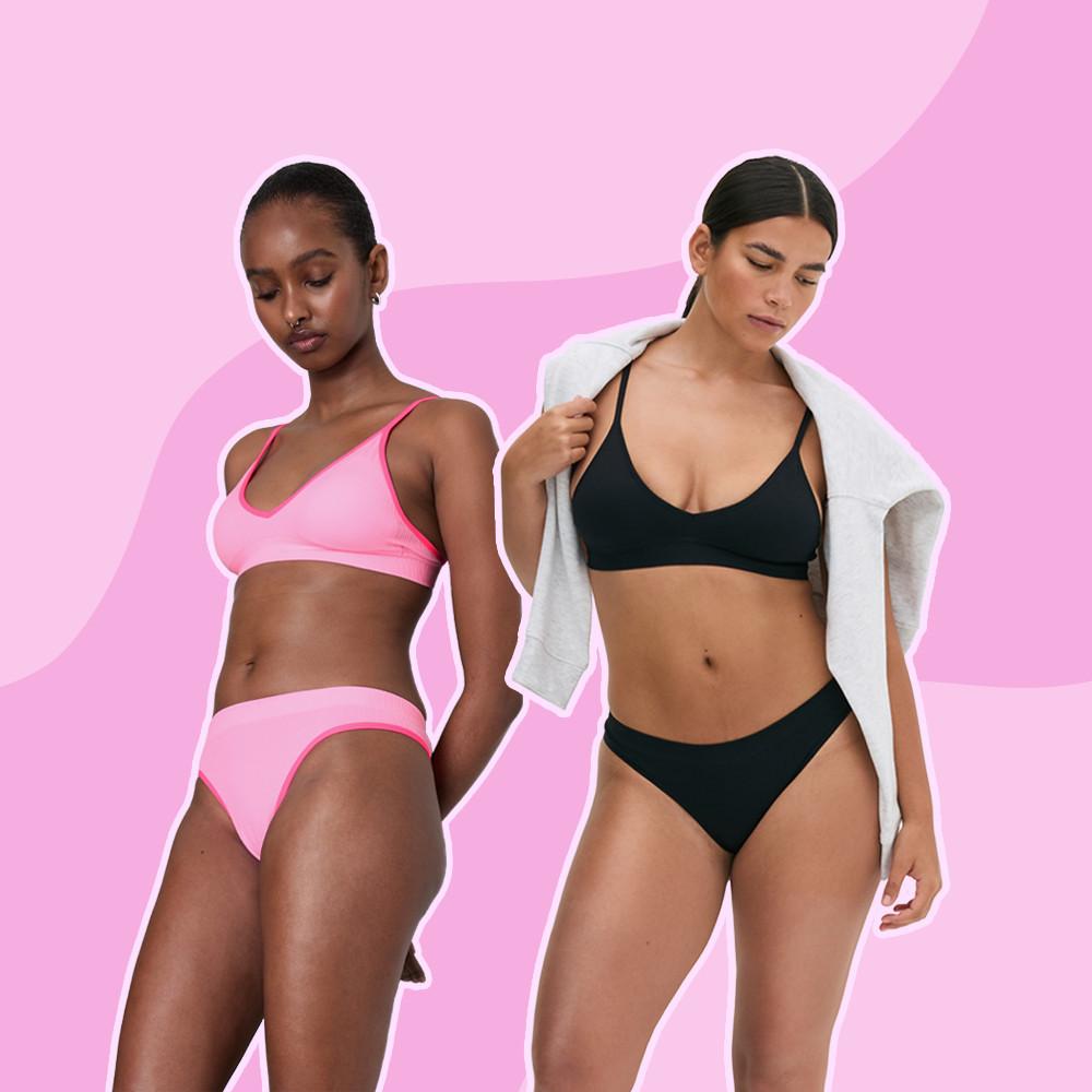 Two women modelling sports bras and briefs in pink and black, one draping a gray hoodie over her shoulder.