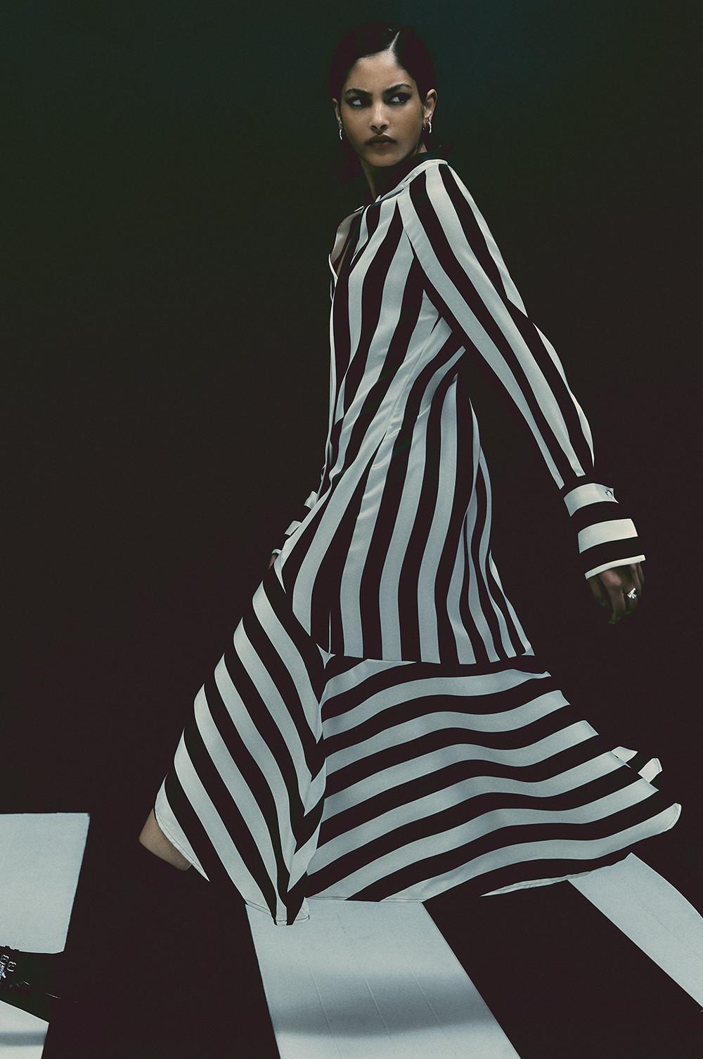Le mannequin porte une robe à rayures noires et blanches