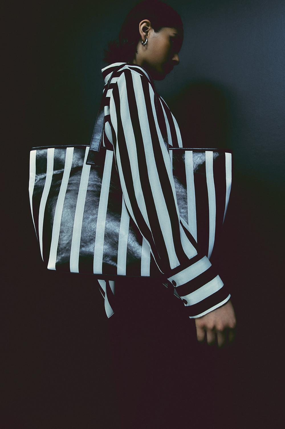 Le mannequin porte une chemise à rayures noires et blanches avec un sac rayé assorti