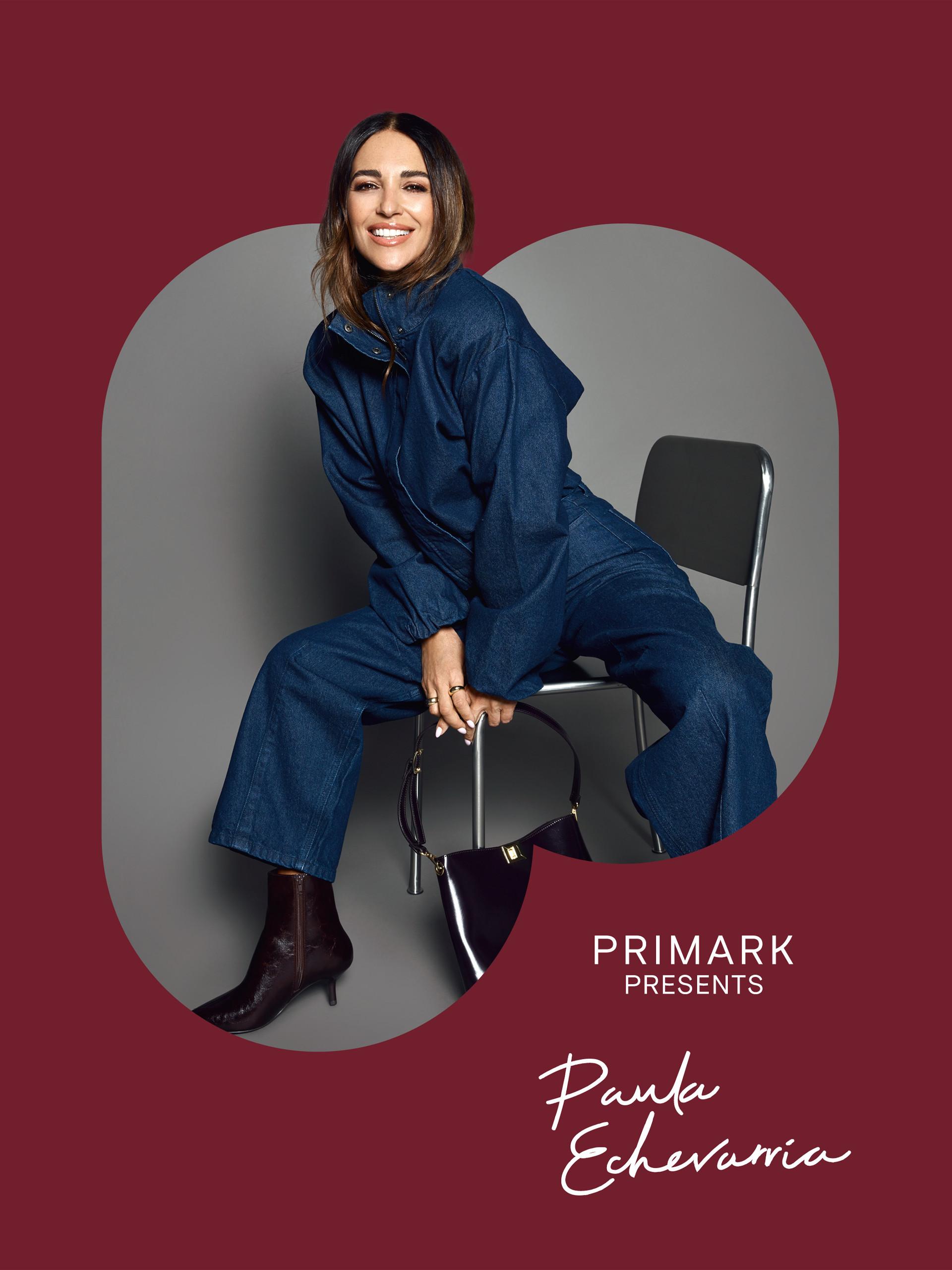 Model wearing black strapless jumpsuit with beige utility jacket draped over shoulder.