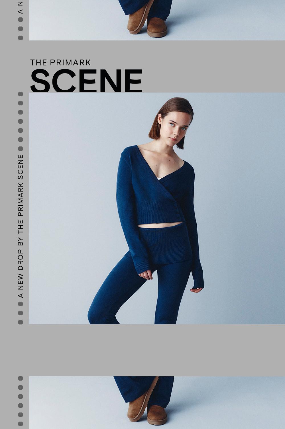 Model wearing navy blue ribbed knit set with wrap-style cropped top and matching pants.