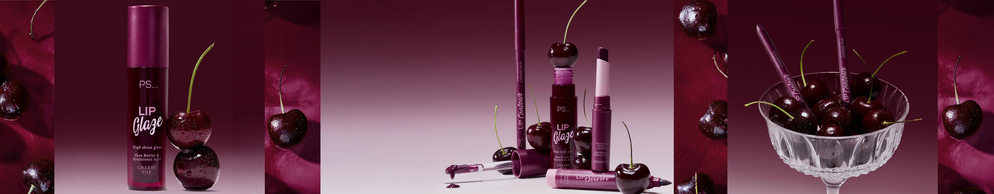 PS Lip Glaze in cherry colour shown with fresh cherries and various lip product applicators against a burgundy backdrop.