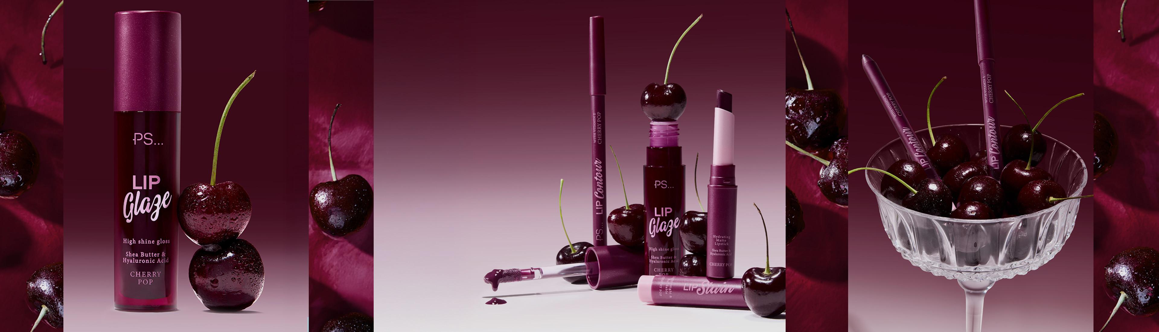 Prodotti PS... Lip Glaze nelle tonalità ispirate al rosso ciliegia, esposti con ciliegie fresche su uno sfondo bordeaux.