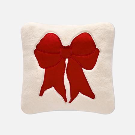 Cream decorative cushion with a large red bow appliqué in the centre.