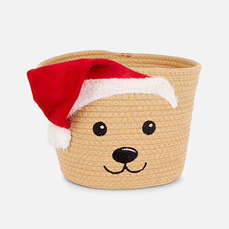 Woven beige storage basket with embroidered dog face features and festive red Santa hat.